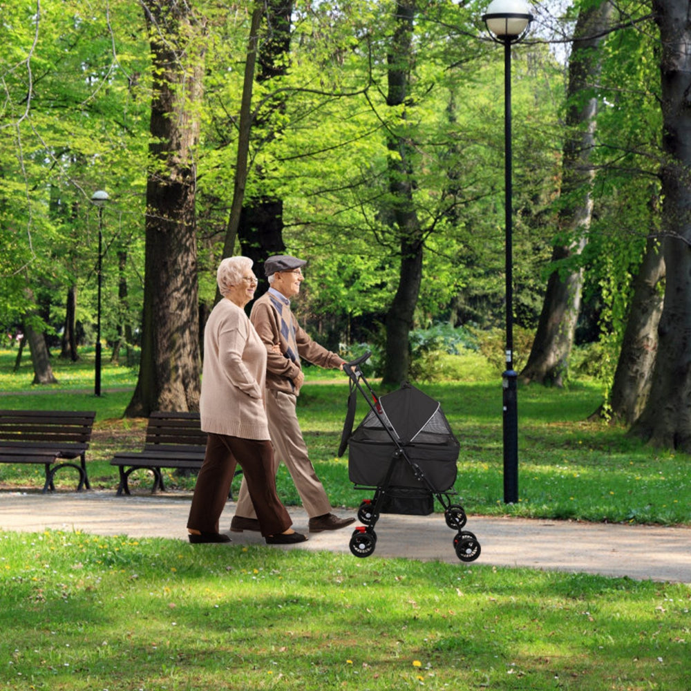 older couple walking a black 4-wheel pet stroller along a tree-lined park path – AGG Gear