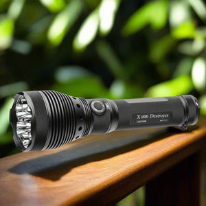 Powertac X10000 Destroyer searchlight resting on wooden railing with blurred green foliage background