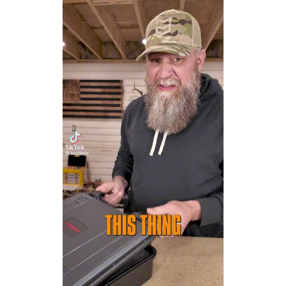 Bearded gear reviewer opening hard case that holds the Powertac X10000 Destroyer flashlight, social media style vertical image