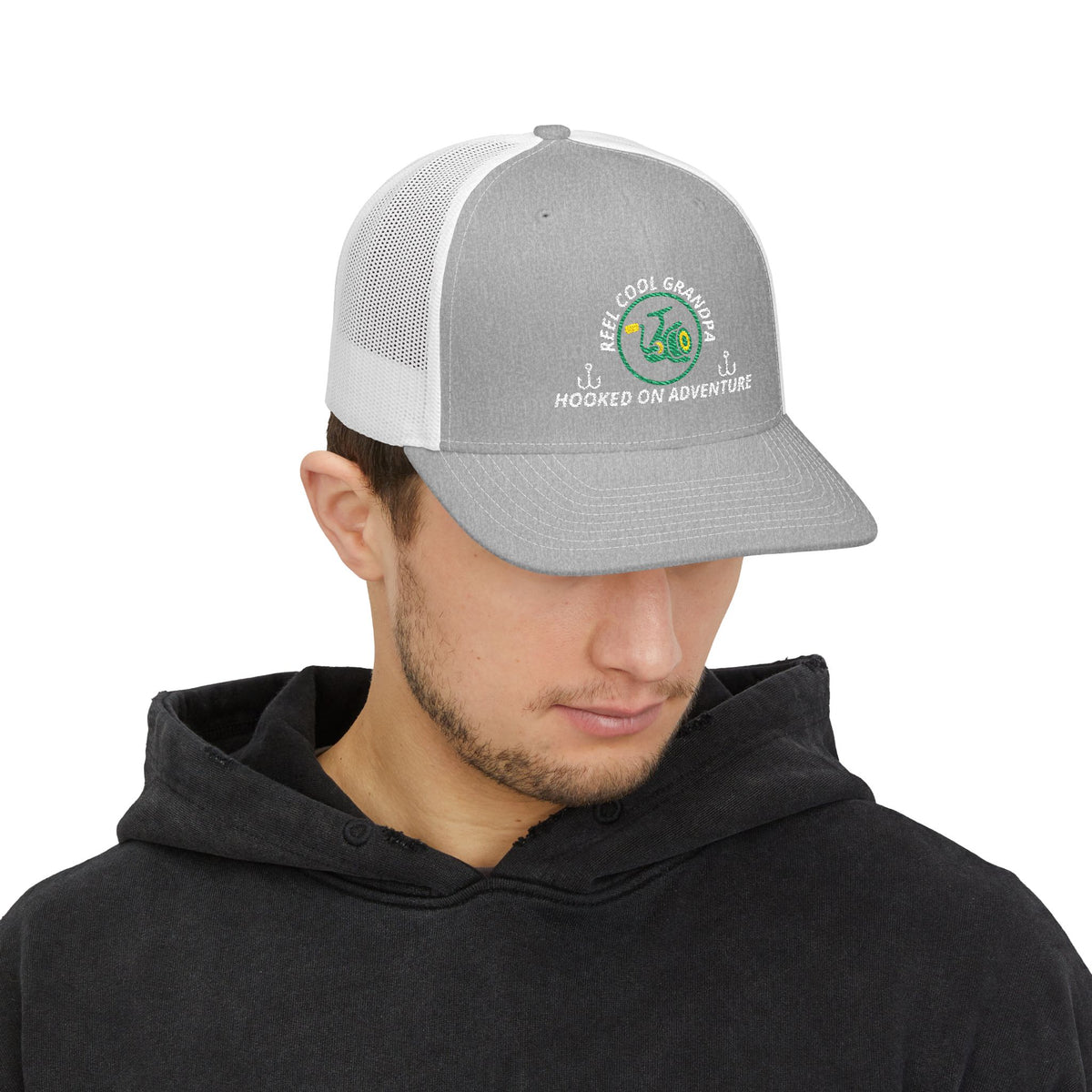 Reel Cool Grandpa embroidered trucker cap on model, front side view, heather grey front with white mesh back