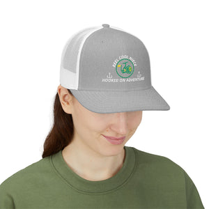 Reel Cool Niece embroidered trucker cap on model, front side view, heather grey front with white mesh back