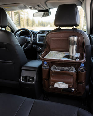 Coffee-brown seat-back organizer with a folding tray, map, stainless steel travel bottle, and storage pockets installed behind the front passenger seat of a compact SUV.